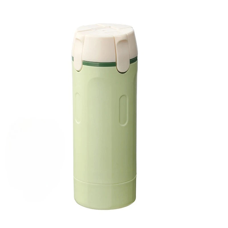 Green 4-in-1 travel dispenser with white lid on a white background