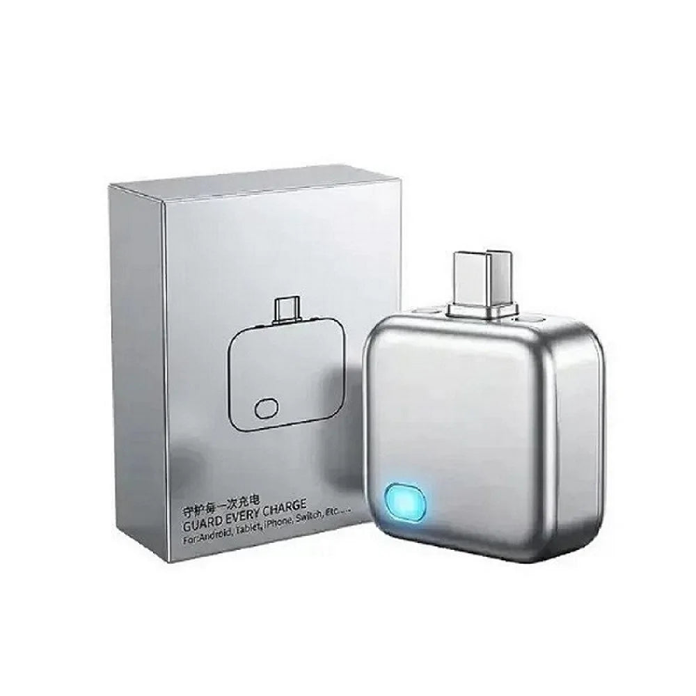 Silver electronic device with a glowing blue light next to its packaging on a white background