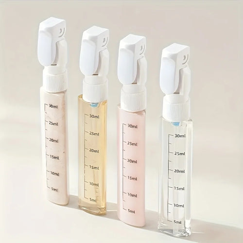 Four transparent spray bottles with white nozzles on a light beige background
